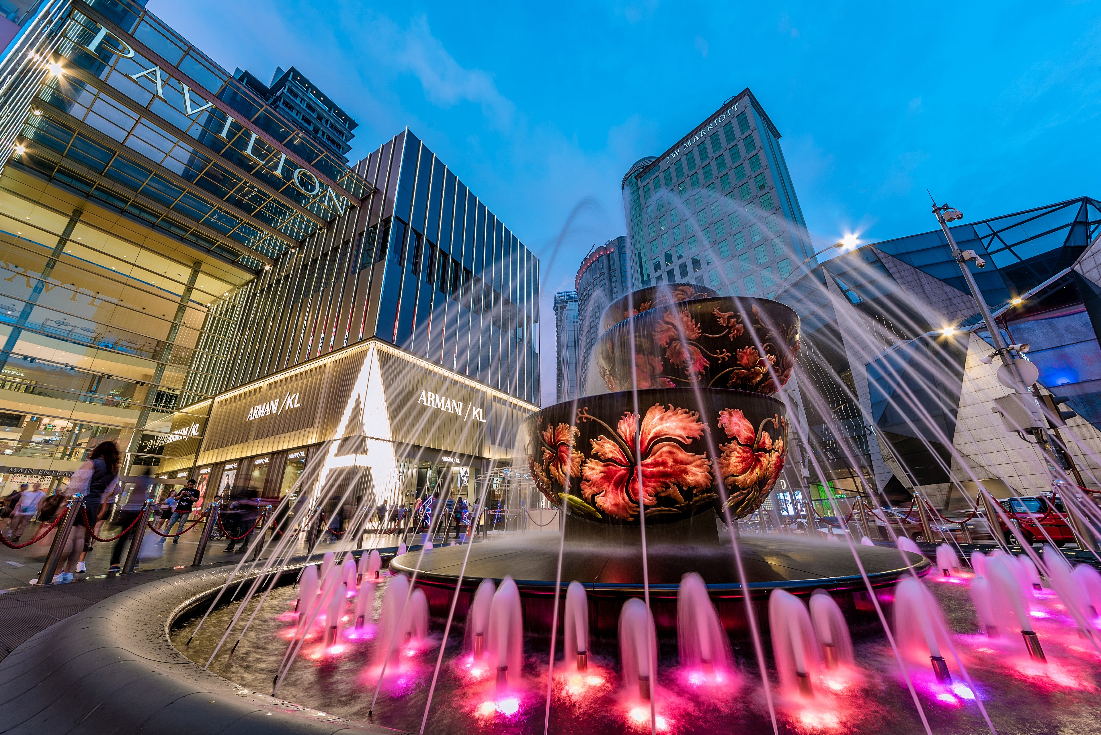 The illuminated fountain plaza outside Pavilion Kuala Lumpur mall at dusk