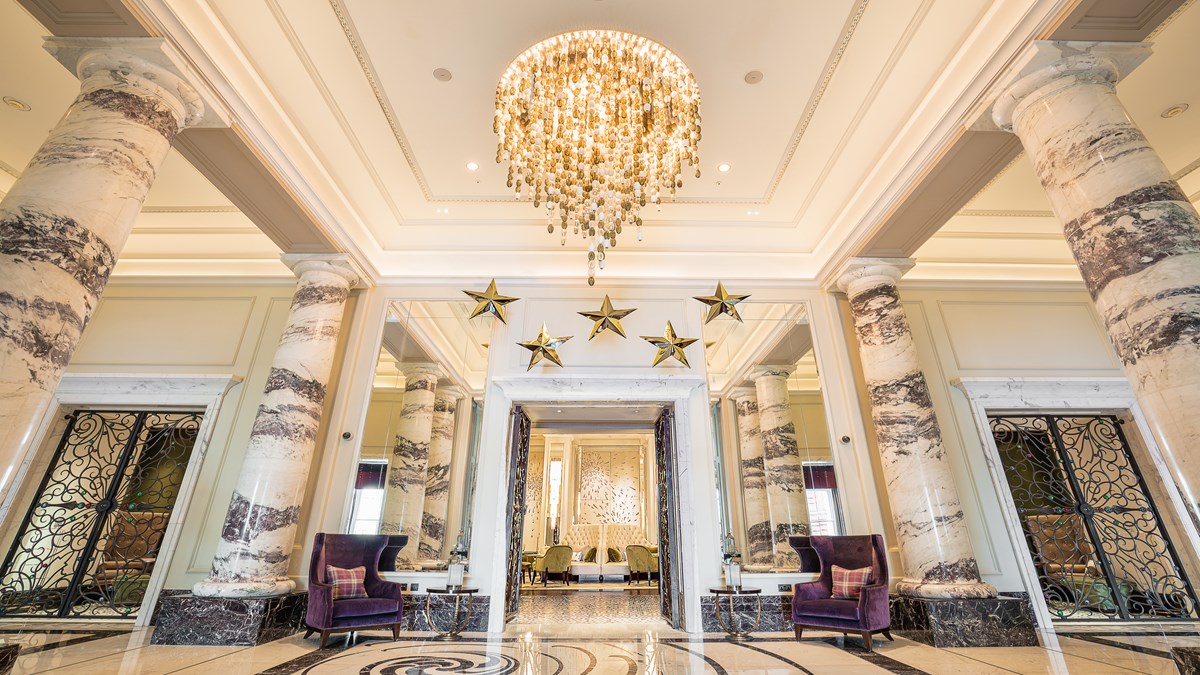Marble columned lobby with chandelier at The Langham London