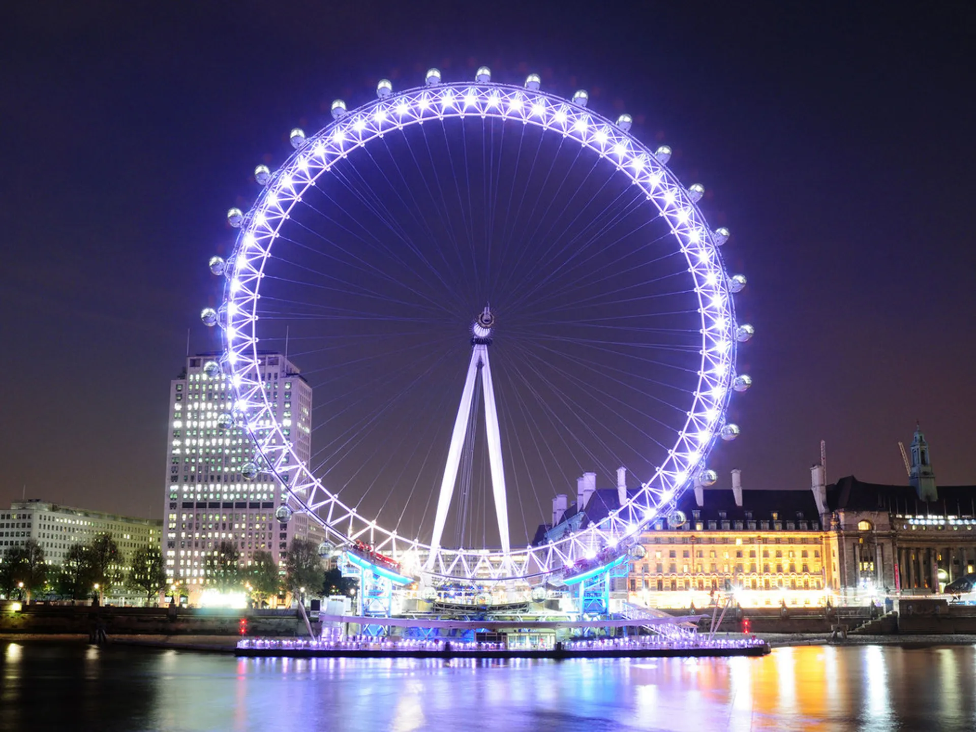 The London Eye illuminated at night on the South Bank