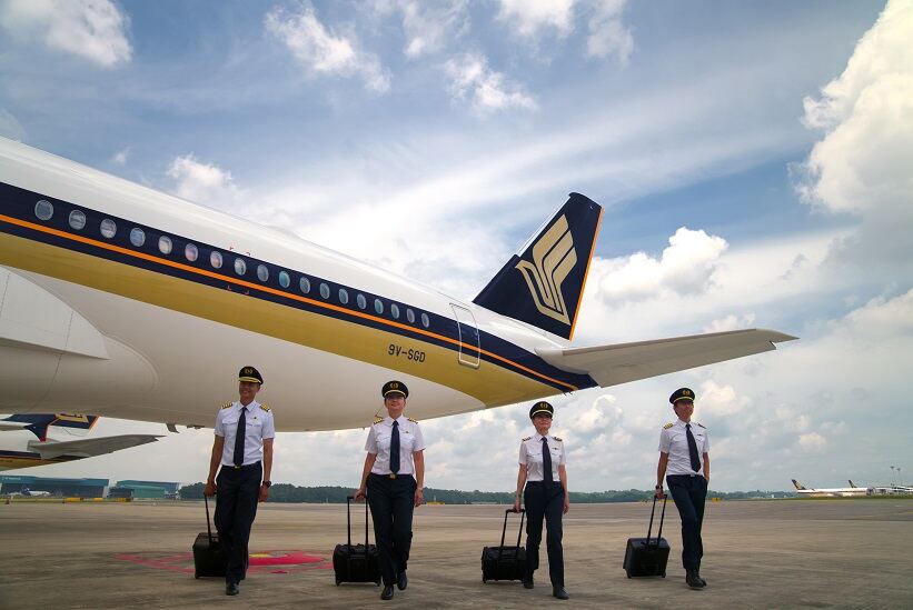 Singapore Airlines pilots walking the tarmac beside an aircraft